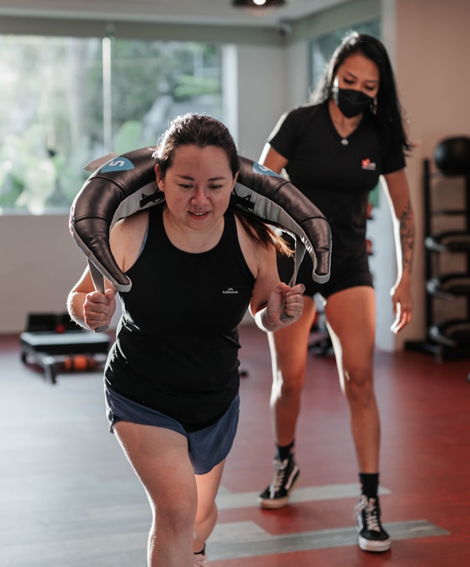 Exercise physiologist supervising a client through a structured rehabilitation exercise program