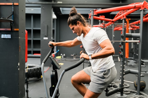 Patient performing cardiovascular rehabilitation on a stationary exercise bike under clinical supervision