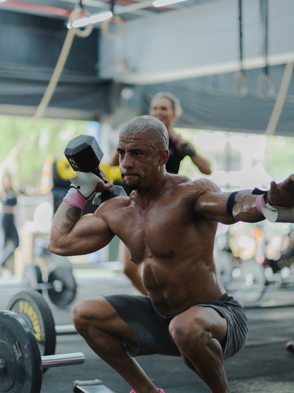 Client performing supervised dumbbell strength exercises during an exercise physiology session